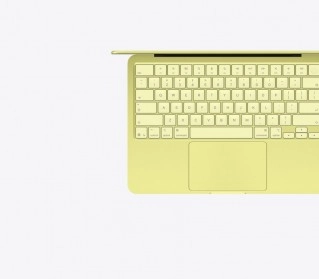Yellow MacBook Neo keyboard and trackpad from above.