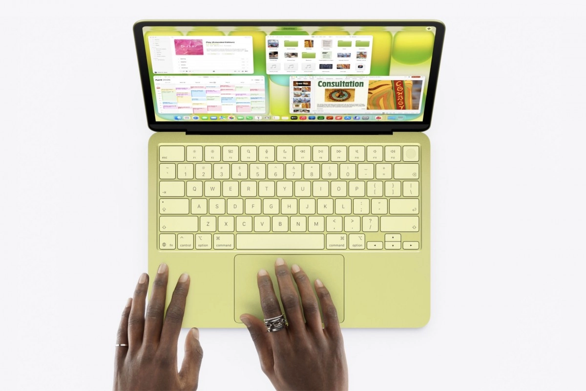 MacBook Neo in lime green, hands using trackpad.