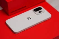 White OnePlus 15T phone on red surface.