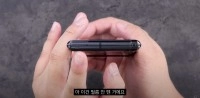 Hands holding closed LG Wing phone showing hinge.