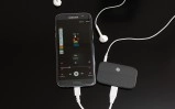 LG phone playing music with earbuds and adapter.