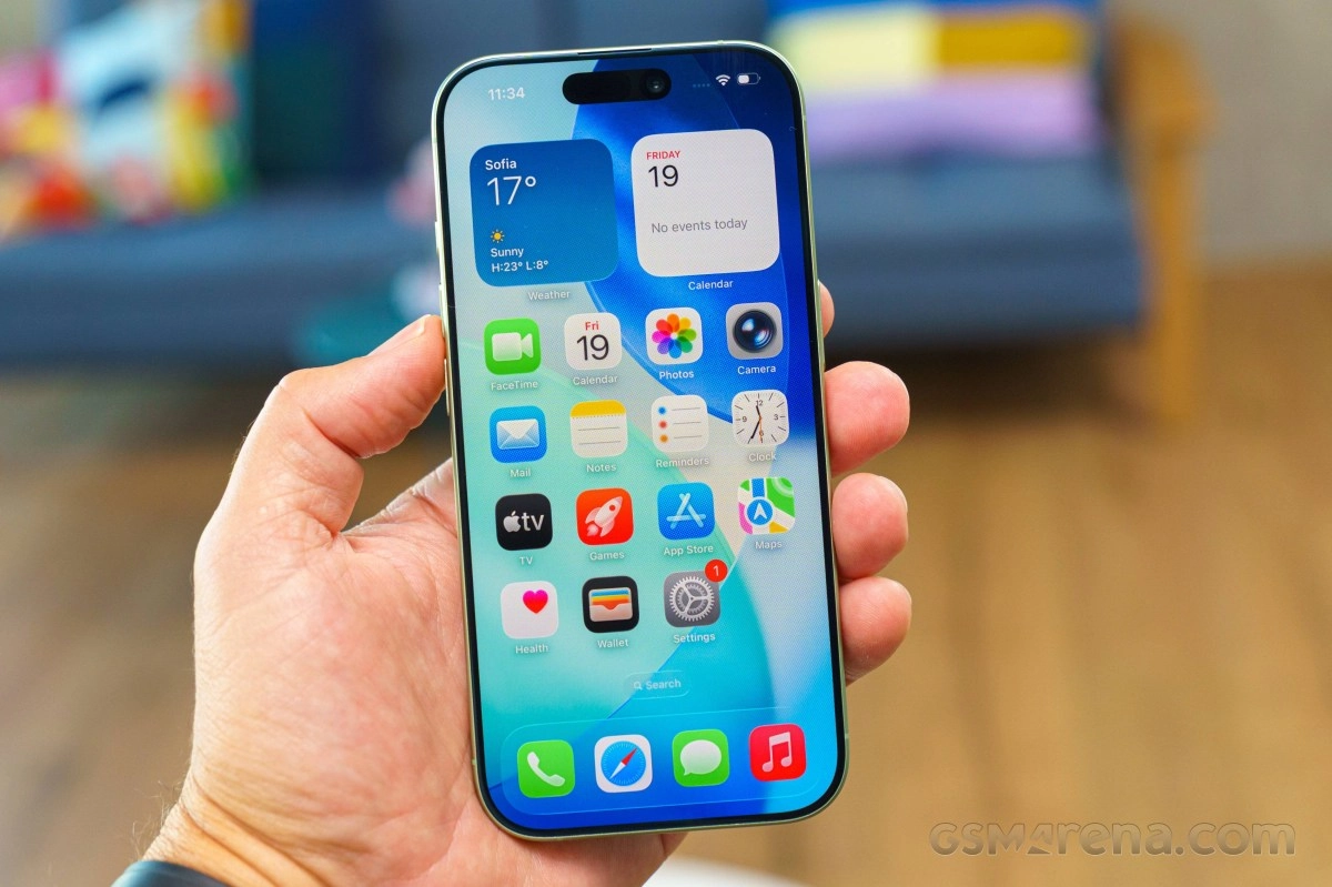 Hand holding modern smartphone displaying app icons.
