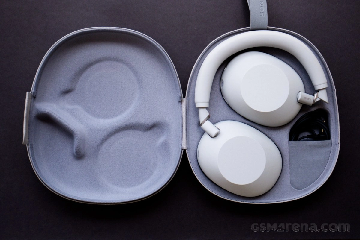 White Sony WH-1000XM5 headphones in open case.