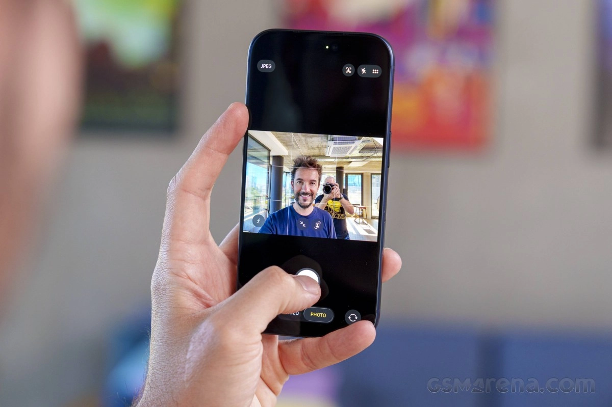Man taking selfie with customized iPhone camera app.