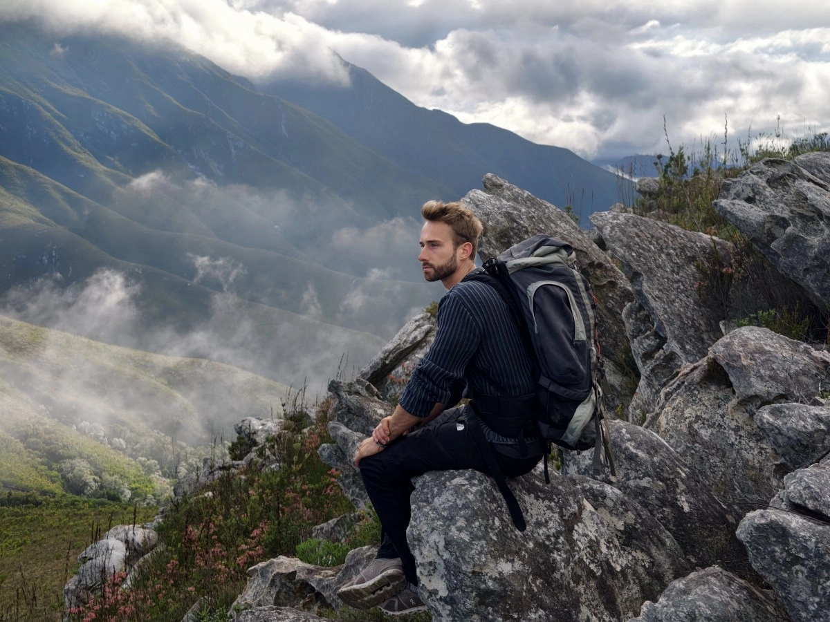 Hiker on rocks with misty mountains, shot on Vivo X300 Ultra.