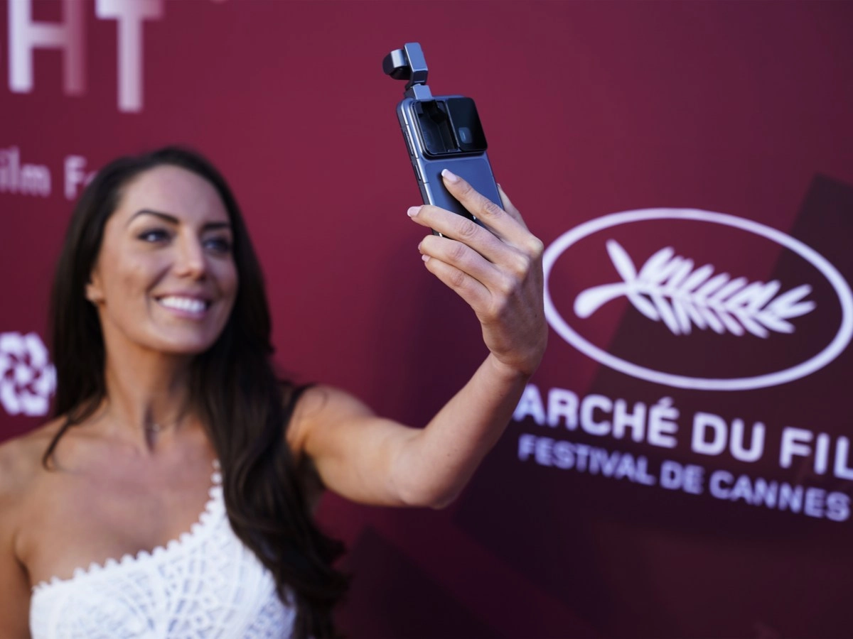 Woman holding smartphone with camera gimbal.