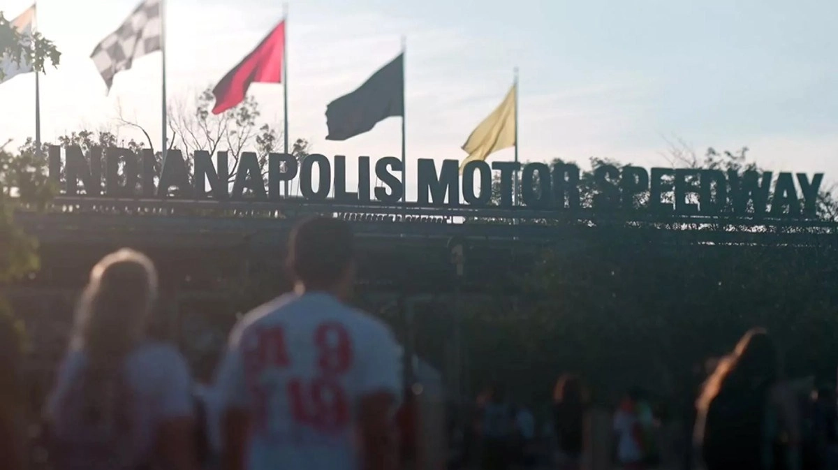 Indianapolis Motor Speedway sign, checkered flag flying.