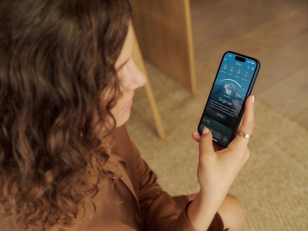 Woman checks Oura app with readiness score