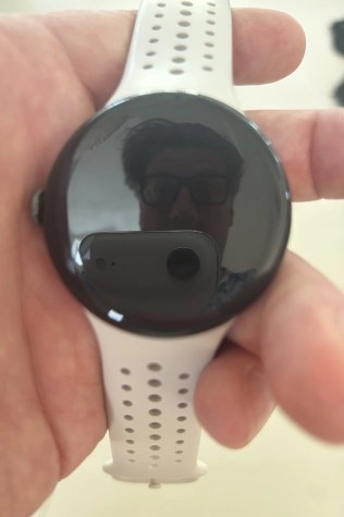 Pixel Watch 5 submerged in water with reflection.