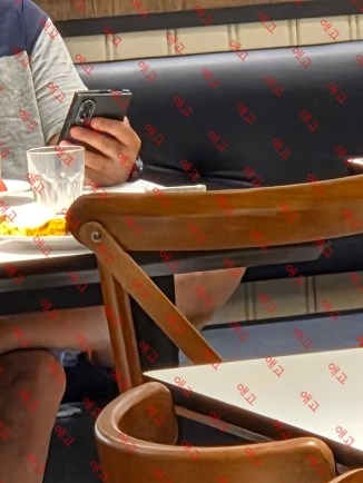 Foldable phone in hand at restaurant table.