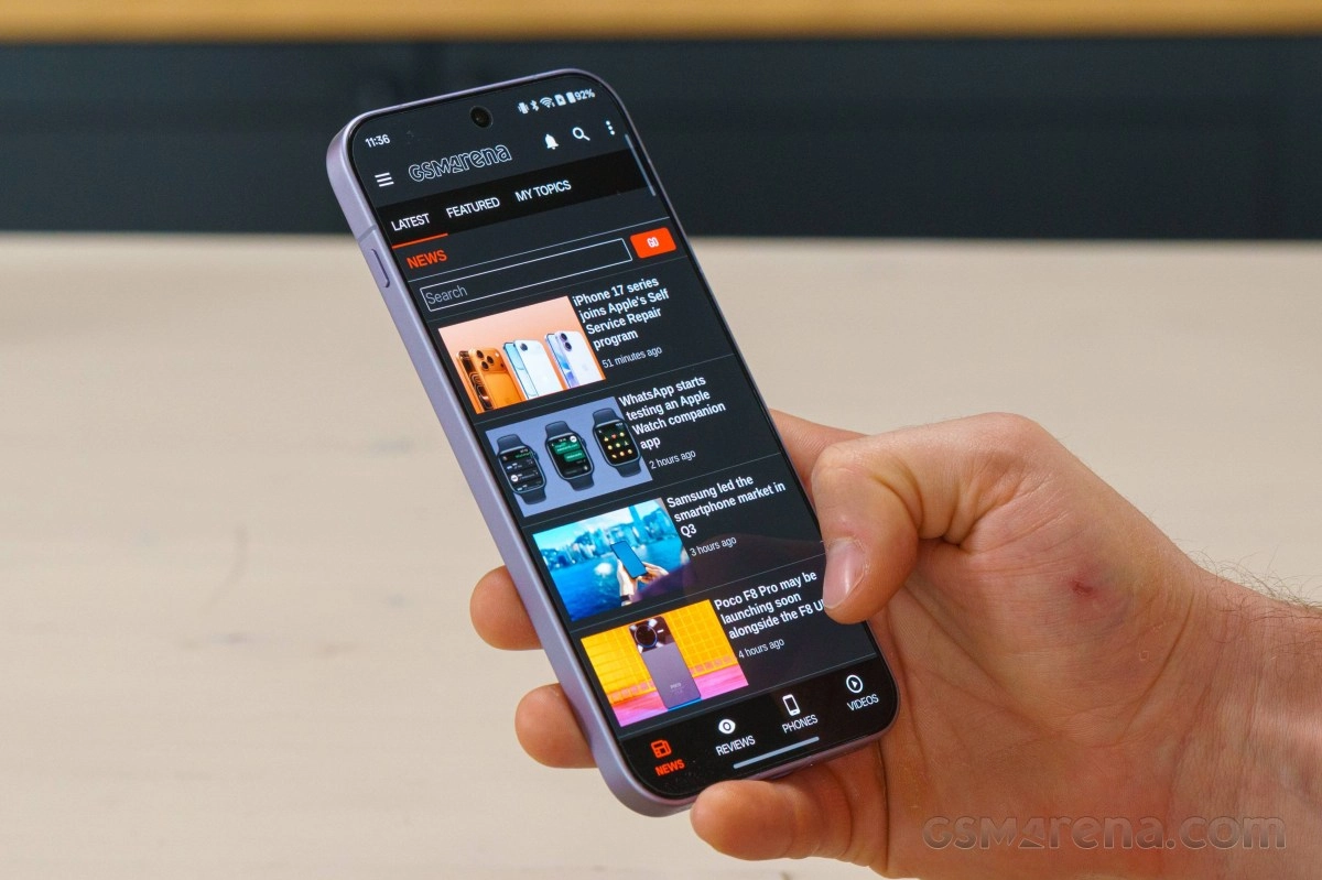 Purple OnePlus phone displaying GSMArena news feed.