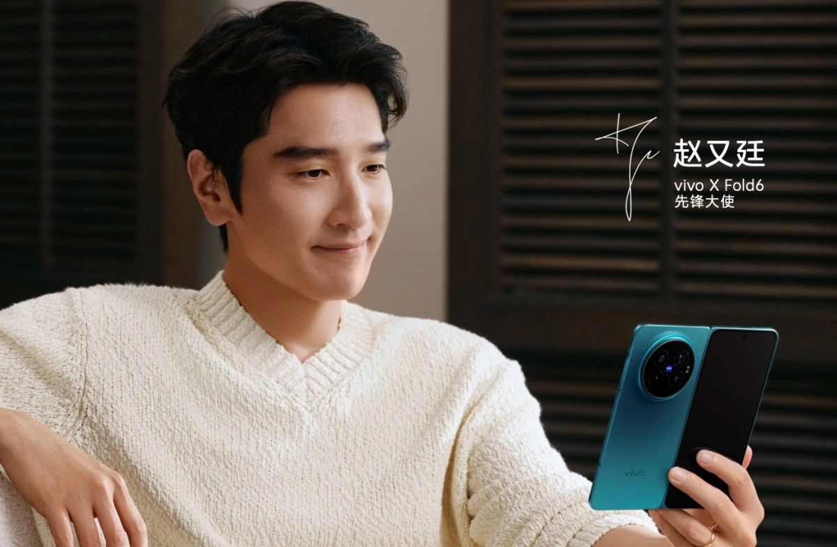 Man holds vivo X Fold6 with teleconverter camera.