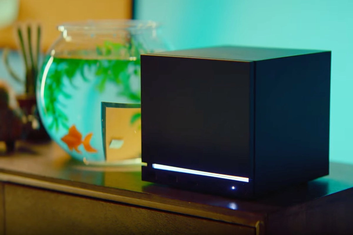 Black Steam Machine gaming console next to goldfish bowl