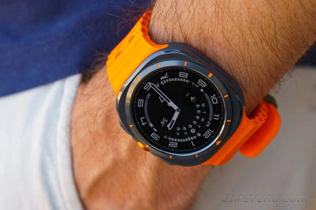 Samsung smartwatch on wrist with orange band