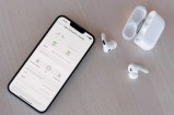 Smartphone with wireless earbuds and charging case.