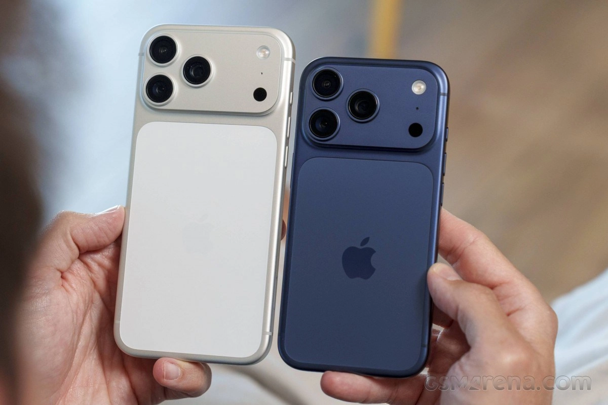 Two iPhones, silver and blue, held in hands.