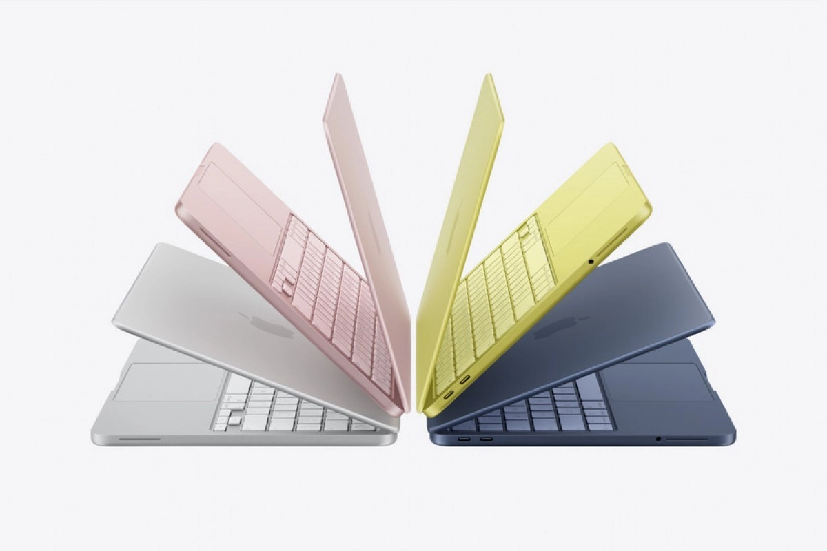 Four colorful Apple MacBook Air laptops open.