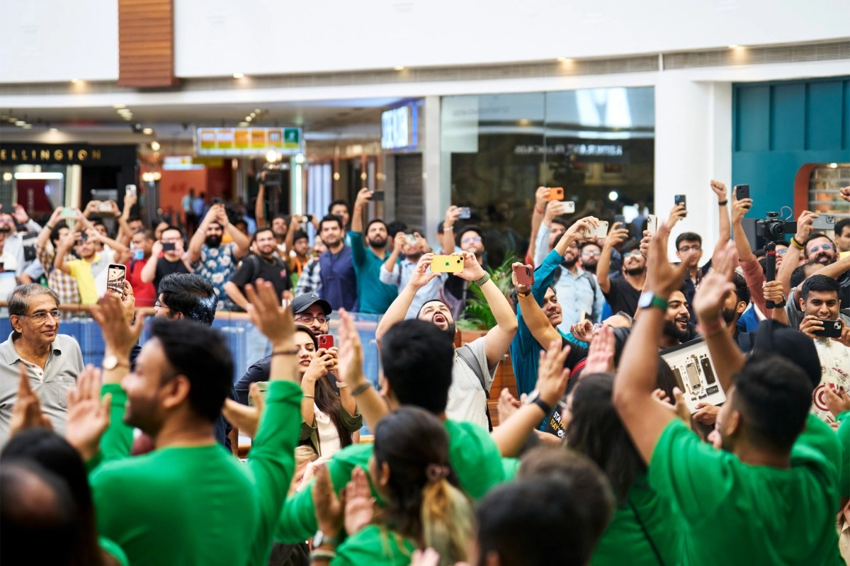 Crowd takes photos with phones at Apple event.