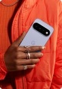 Google Pixel phone held in orange jacket.