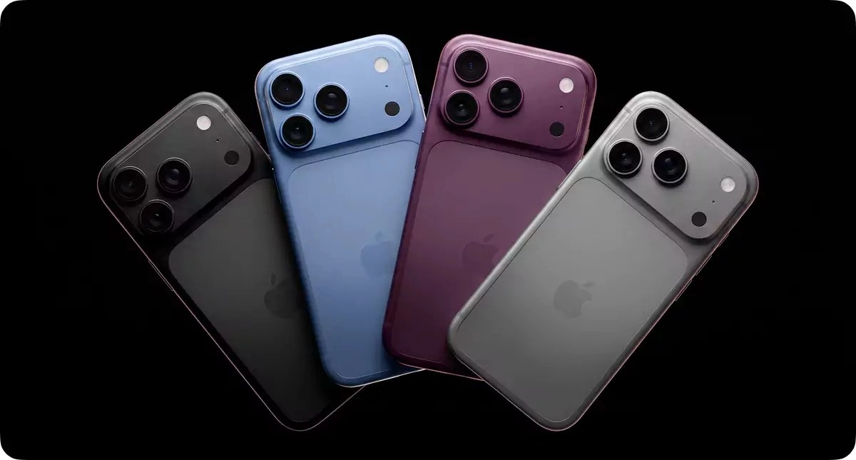 Four iPhones in different colors on black background.