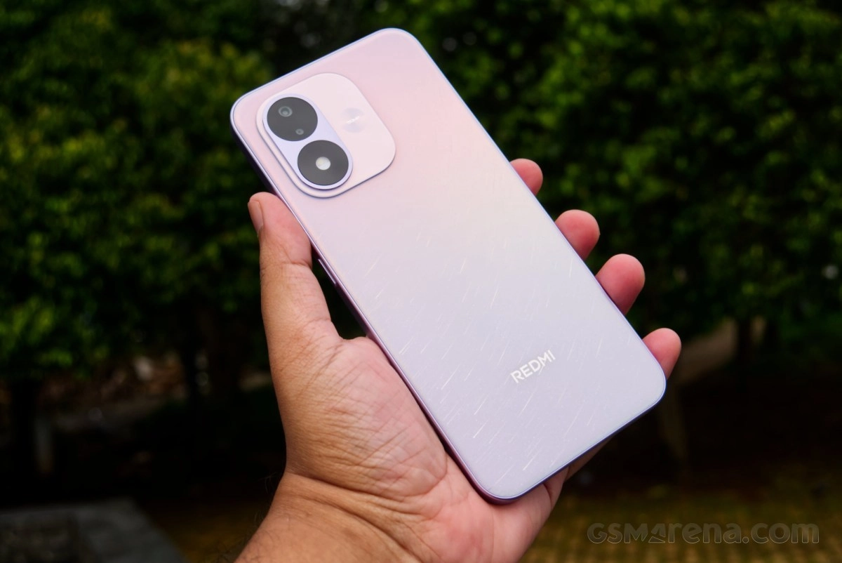 Redmi phone with dual cameras in hand.
