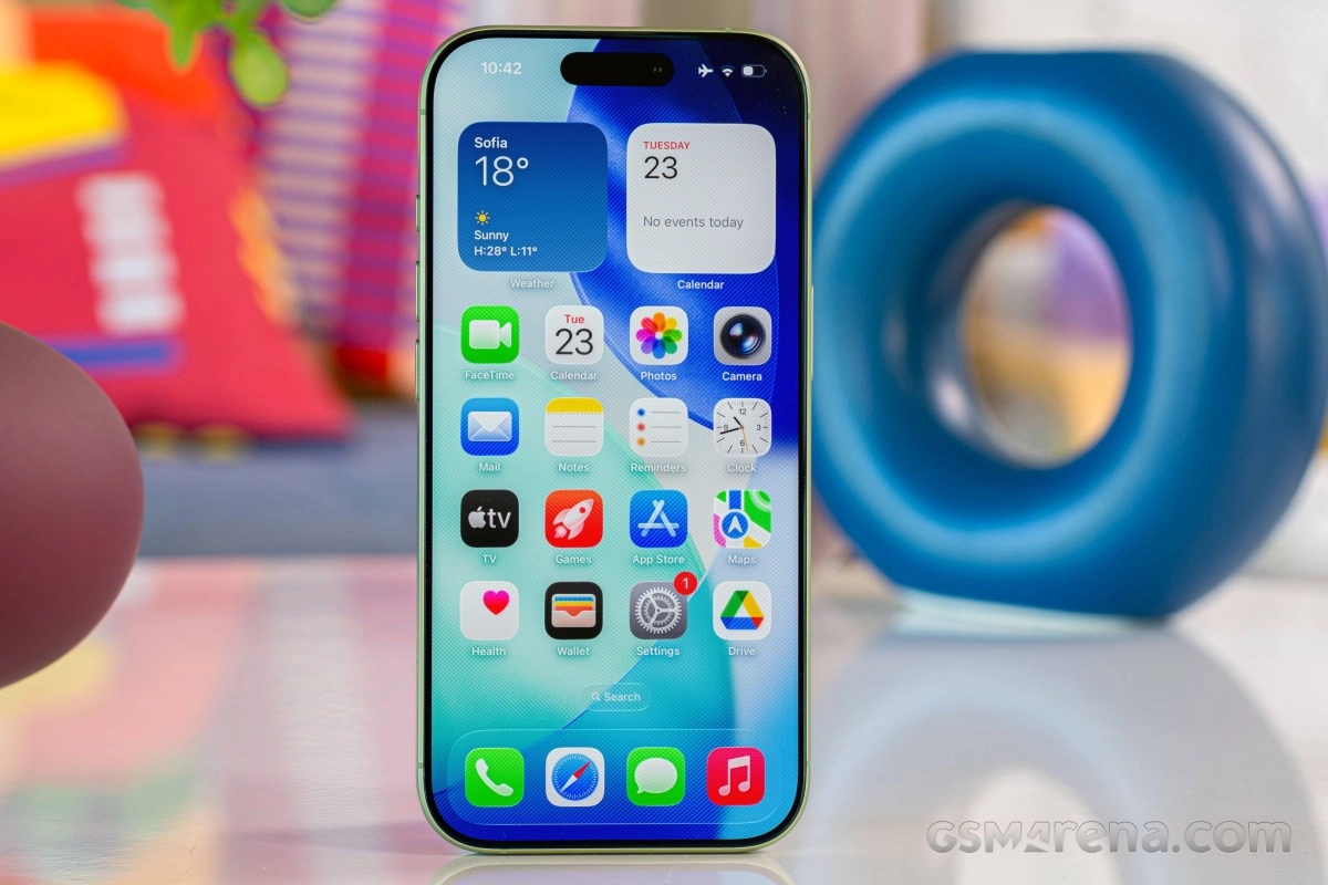 Light green iPhone with Dynamic Island displaying home screen.