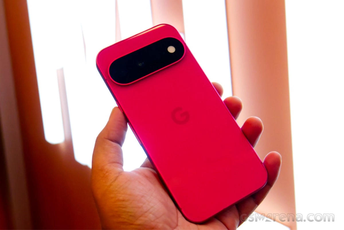 Pink Google Pixel 11 phone held in hand.