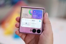 Hand holding pink Samsung Galaxy Z Flip foldable phone.