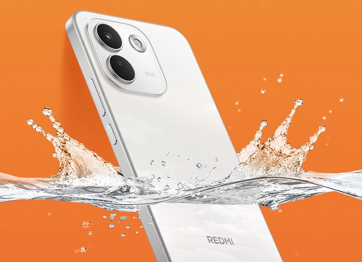 White Redmi phone in water splash.