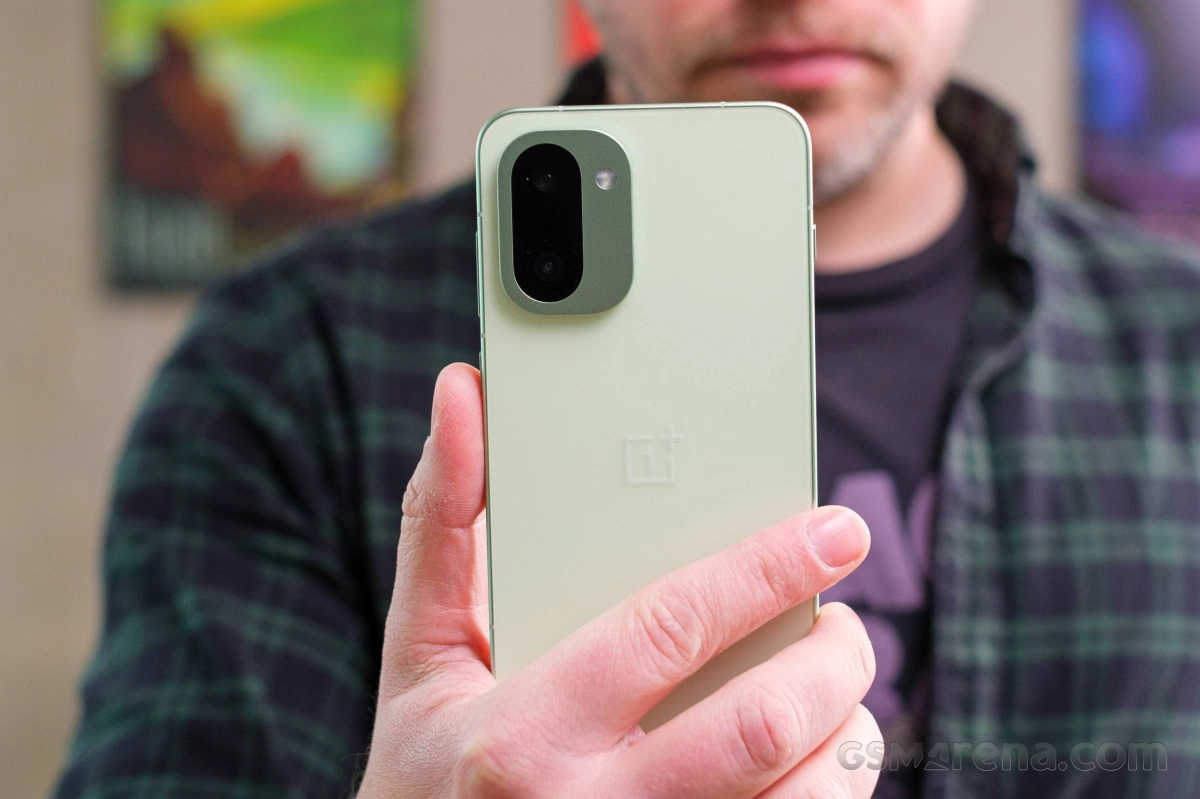 OnePlus phone with dual camera held.