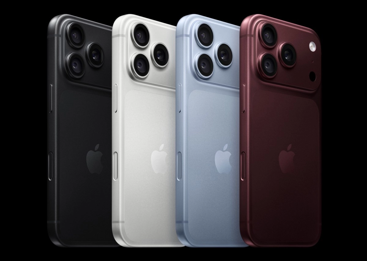 Four iPhones in different colors on black background.