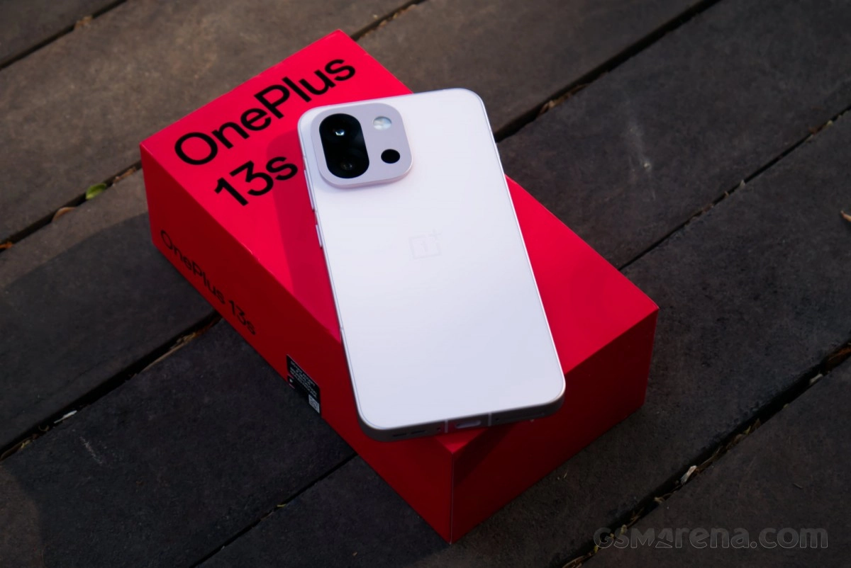 White OnePlus 13s phone on red box.