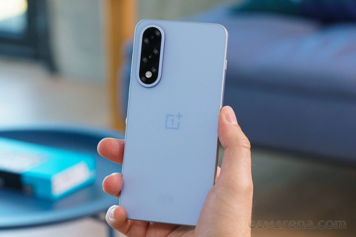 Hand holding light blue OnePlus smartphone