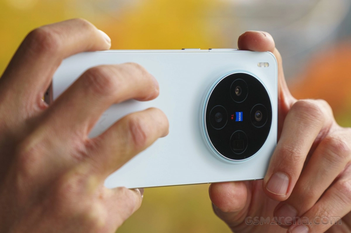 White phone with round camera held by hands