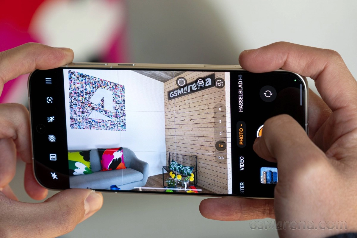 Hands holding smartphone, taking picture of living room.