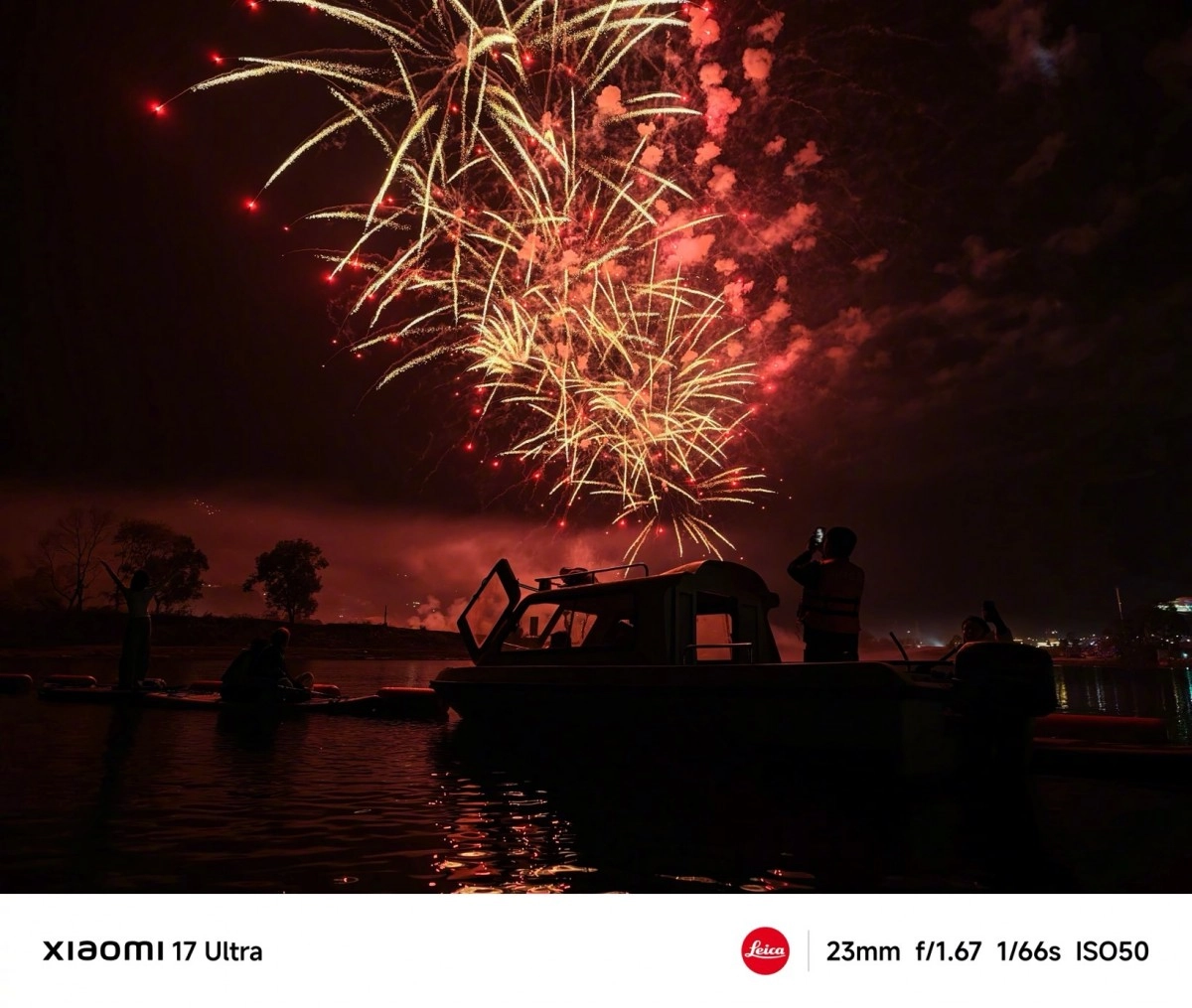 Fireworks over water with boat and people.