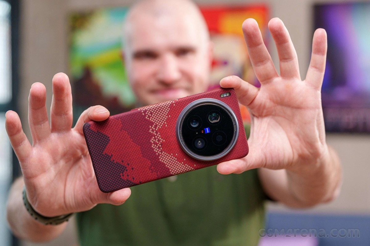 Red patterned phone with large camera, held by man.