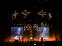 Band performs live on stage with illuminated birds.