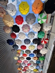 Colorful open umbrellas hanging above a street