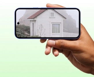 Hand holding Google Pixel 10a, showing small house.