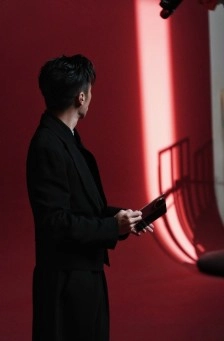 Man holding Honor Magic V6 tablet, red background.